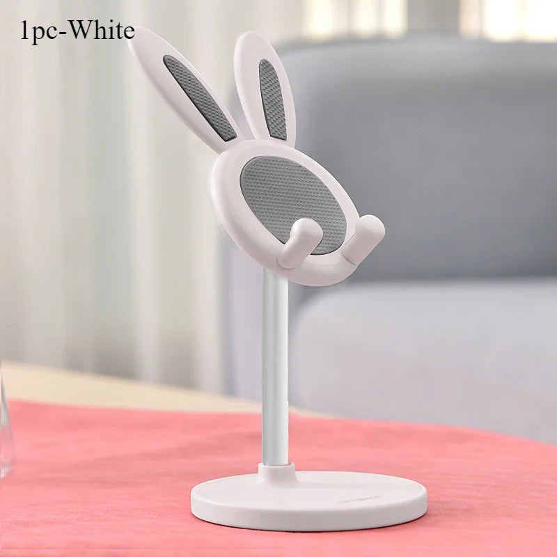 White phone stand with bunny ears on a pink surface