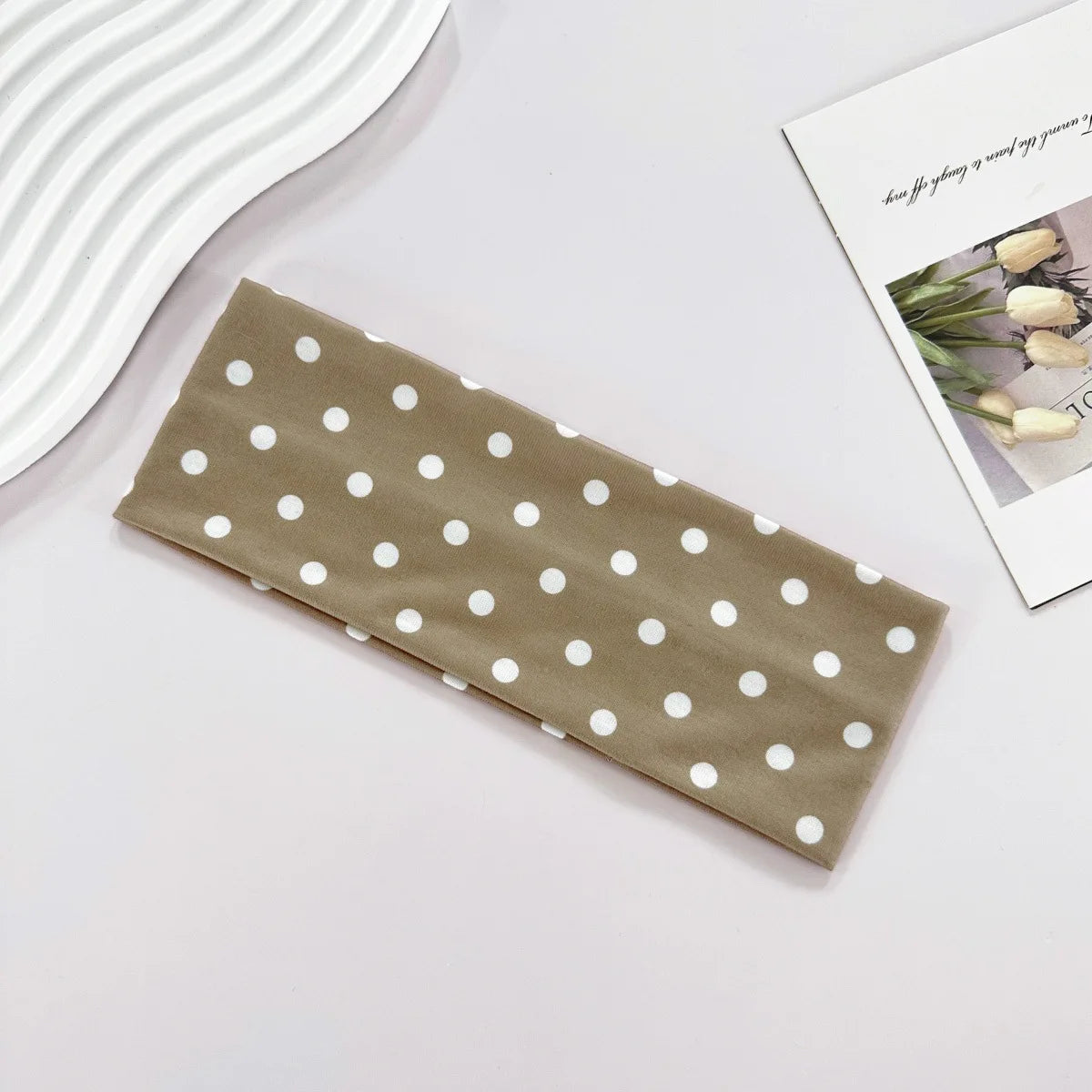 Brown fabric with white polka dots on a light gray surface