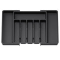 Black plastic drawer organizer with multiple compartments on a white background