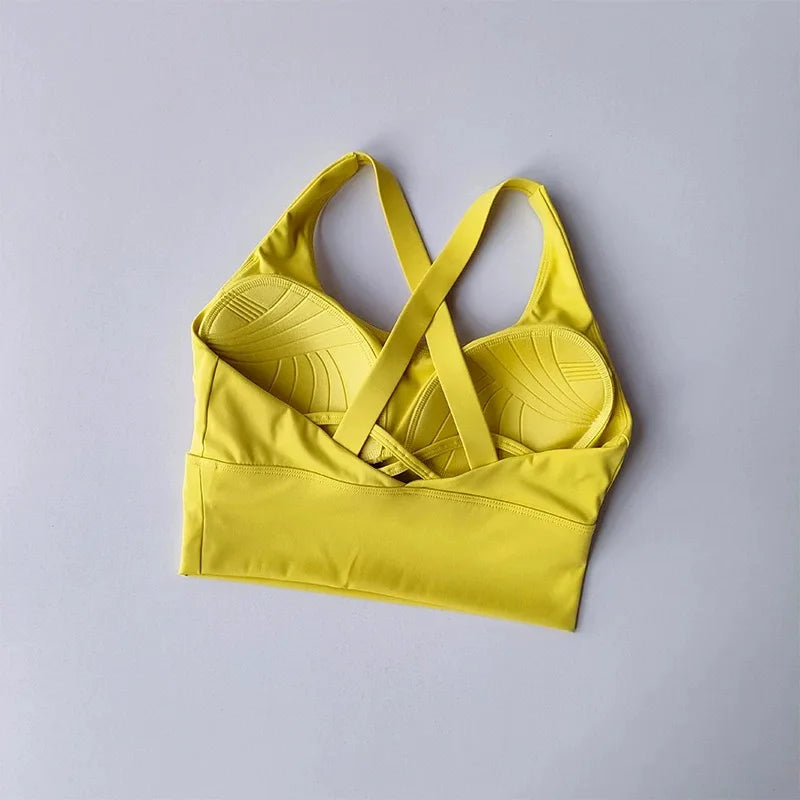 Yellow sports bra and tank top set on a light gray background