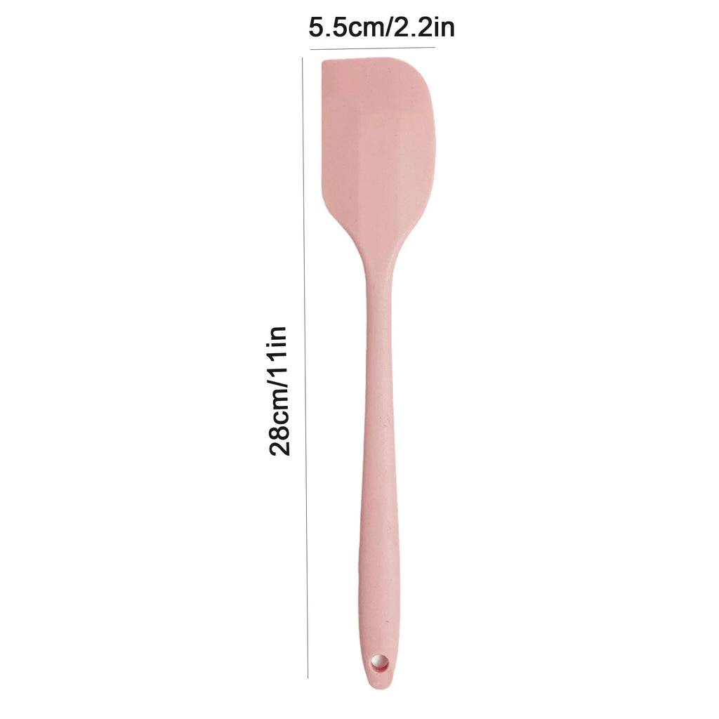 Pink spatula with measurements on a white background