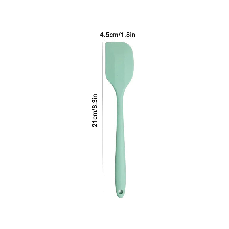 Mint green spatula with measurements on a white background