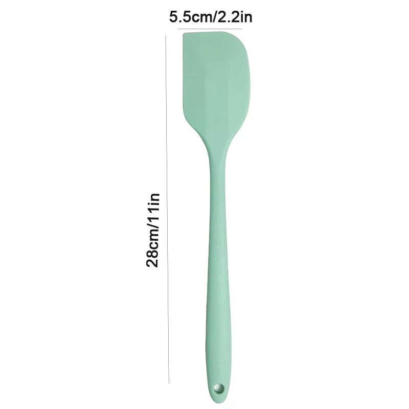 Mint green spatula with measurements on a white background