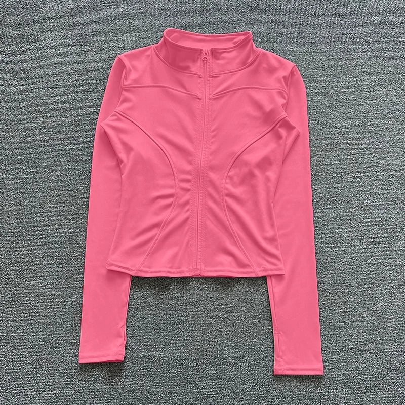 Pink long-sleeve athletic top on a gray textured background