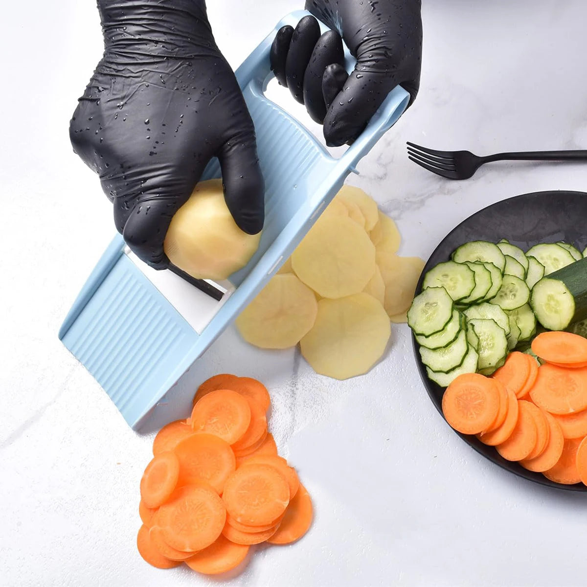 Person slicing vegetables with a mandoline slicer on a white surface.