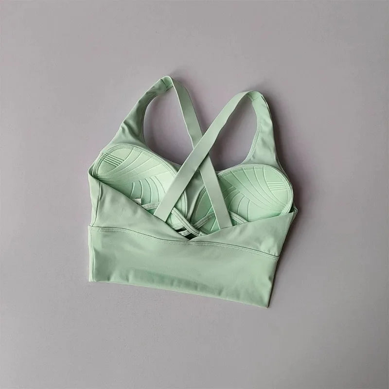 Light green  cross sports bra on a gray background