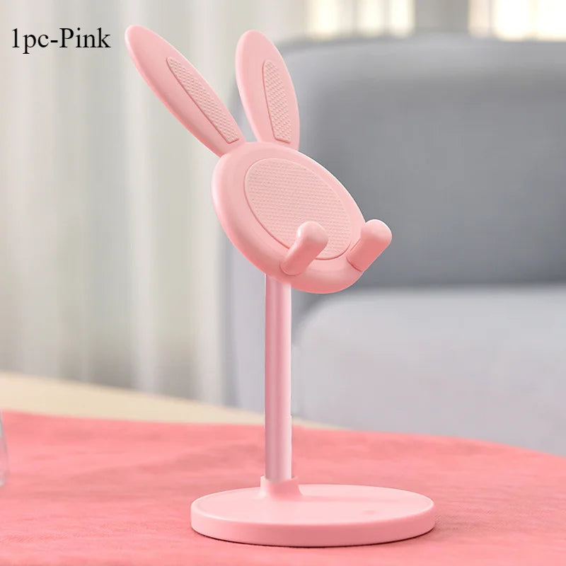 Pink bunny-shaped phone stand on a pink surface with a blurred background