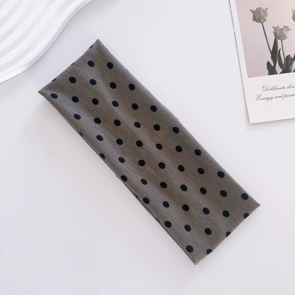 Dark gray fabric with black polka dots on a white surface